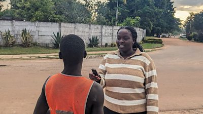 Womba interviewing contributor in field