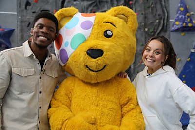 Rhys Stephenson and Evie Pickerill stood next to Pudsey Bear smiling