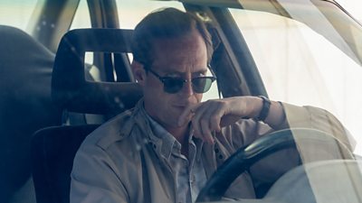Stephen Campbell Moore on set of The Gold in character as Tony Lundy, who is sat at the wheel of a car wearing sunglasses