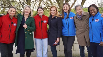 Seven people, two of them in red Bargain Hunt branded jackets and 2 in blue Bargain Hunt branded jackets stood together in a line.