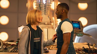 The thirteenth doctor (Jodie Whittaker) and the fifteenth doctor (Ncuti Gatwa) stand in front of the Tardis console
