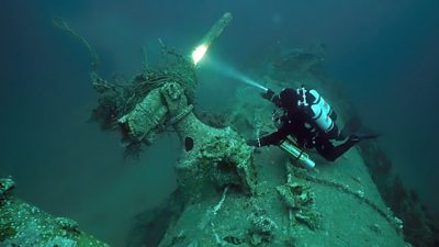 Diver Chris de Putron inspects the gun on underwater UC18