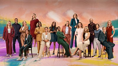 A group shot of seventeen presenters, pundits and commentators, some sitting down on chairs and high stools, and others standing up. They are all dressed smartly and smiling. The background is made up of pastel coloured paints blended together.