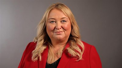 Rhuanedd Richards wearing a black to and red blazer