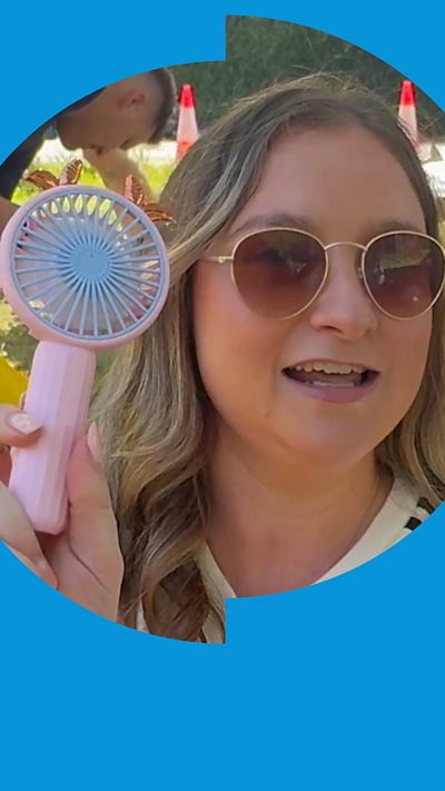 Oasis fans holding a small pink fan