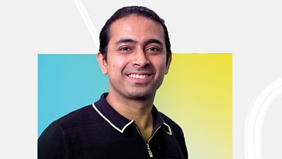 Aniruddh Dimri looks into the camera smiling, wearing a black zip-up polo shirt