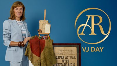 Fiona Bruce stood next to a table holding VJ Day artefacts including an old newspaper