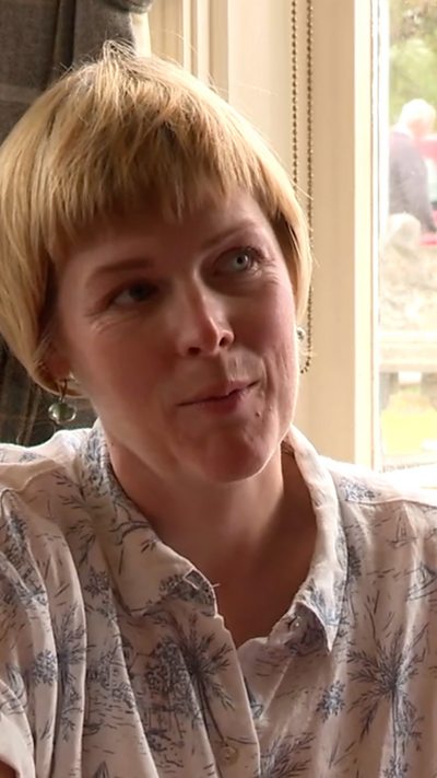 Leanne Parry, menyw gyda gwallt melyn byr yn gwisgo crys gwyn