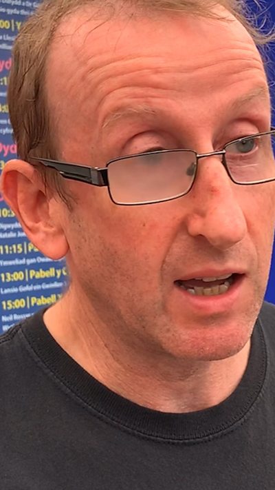 Lefi Gruffydd yn siarad â Garry Owen ar faes yr Eisteddfod