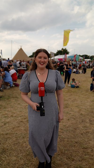 Bethan Bushell, menyw ifanc mewn ffrog yn gwenu at y camera