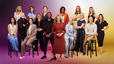 A group shot of 16 presenters against a colourful background of pink yellow and purple hues. Some are stood and some are sat down. All of them are smiling.