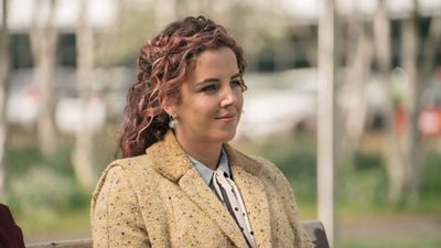 Jamie-Lee O'Donnell stood outside wearing a woll coat, half smiling