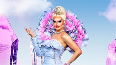 A drag queen wearing a baby blue ruffles against a blue sky