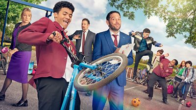 A boy on a bicycle is doing a wheelie in school uniform and a group of kids mess around on the playground while teachers watch on