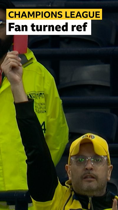 A fan holding a red card