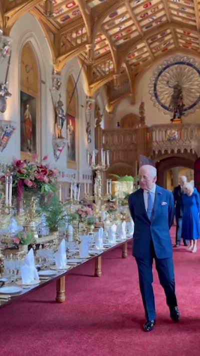 King Charles walks next to the banquet table