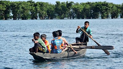 Five boys in a boat in the wetlands, Tanguar Haor in Bangladesh
