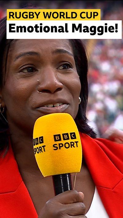 Maggie Alphonsi in red blazer speaking into yellow BBC microphone.