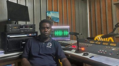 Journalist Fredrick sitting in radio studio in Solomon Islands