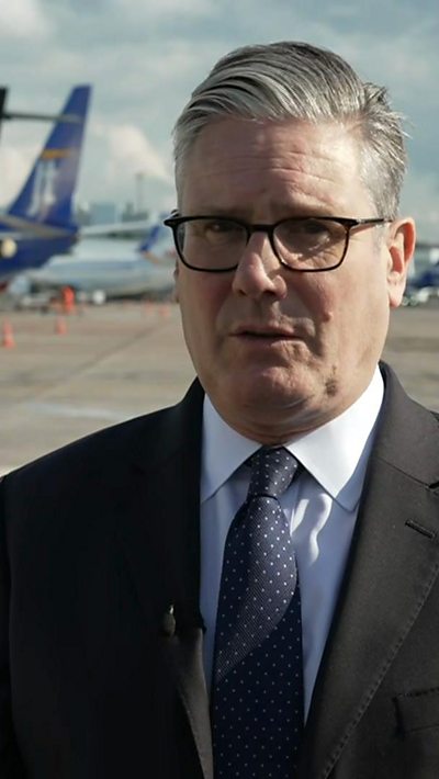 Keir Starmer wearing a tie on an airport runway