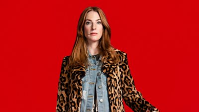 Rosalie Craig in character as Kitty Eckersley in Riot Women. Wearing a leopard-print jacket over a denim shirt, she stares directly to the camera. 