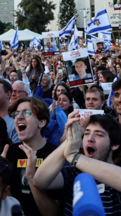 Crowds cheer and wave Israeli flags in Hostages Square in Tel Aviv.