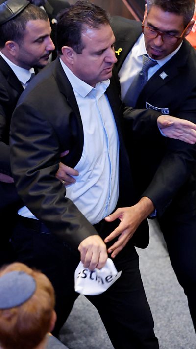 A man being escorted from the Knesset