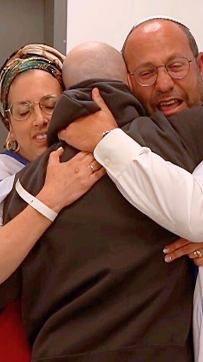 Two relatives embrace a freed Israeli hostage.
