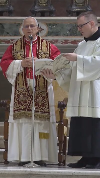 Pope prays in front of a standing microphone in the Sistine Chapel