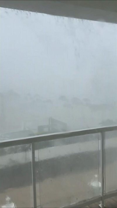 Thick mist and rain covers a coastal view from a balcony.