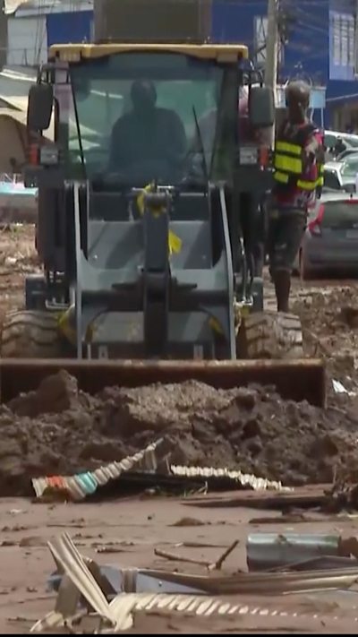 Two men are cleaning up the streets of Jamaica after Hurricane Melissa made landfall.