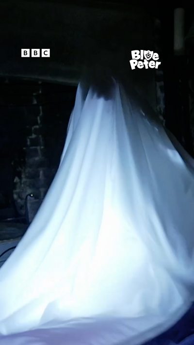 Shini dressed as a ghost in a bed sheet.