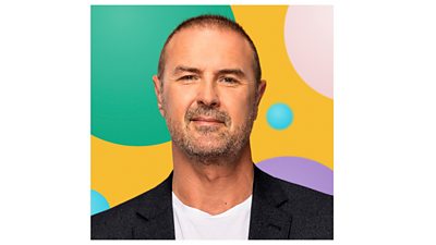 Paddy McGuinness headshot. He is smiling. The background is made up of multicolour graphic circles on a yellow background.