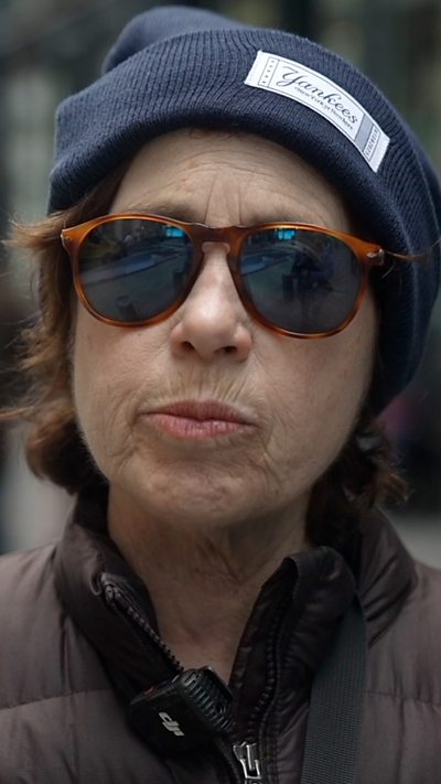 A woman is answering a question on the street about the next New York City mayor.