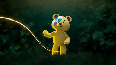 Pudsey, a yellow bear with a colourful eyepatch is looking at a golden thread of light. 