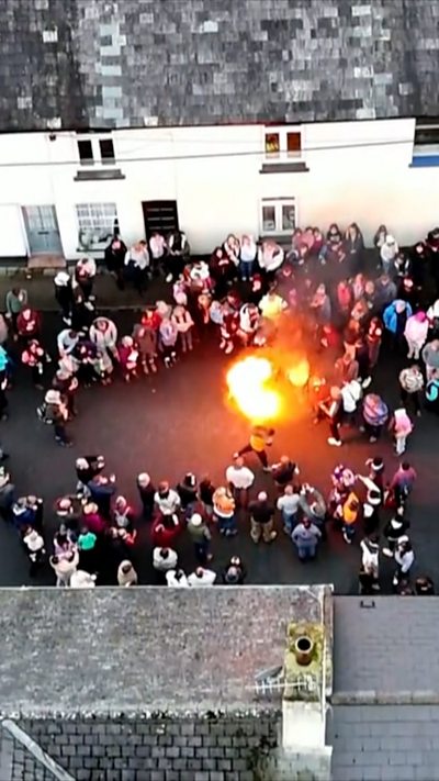 Drone footage of children's tar barrel rolling