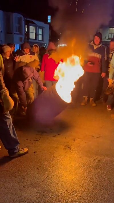 Crowds dodge flaming barrels as they come through the crowd