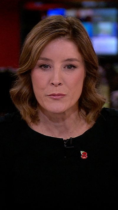 BBC newsreader wearing a black top and Remembrance poppy