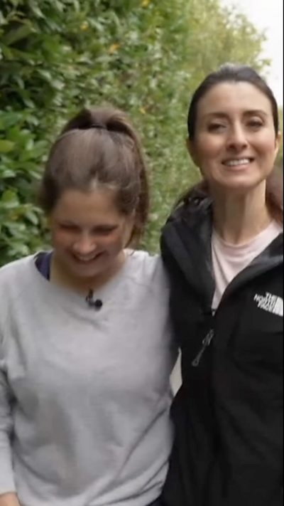 Lindsey Burrow and Amy Garcia smile and walk together.