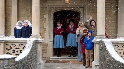 People gather in the doorway of a snowy Nonnatus House to wave to people outside