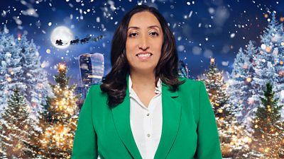 A woman in a green suit stands in front of a Christmas background