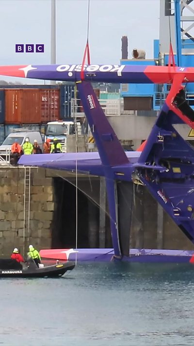 Keyframe #1 A purple racing yacht being lifted out of the water