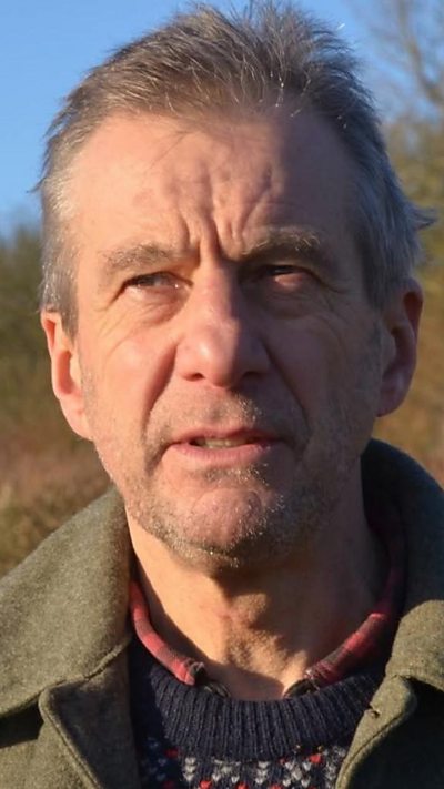 Michael Dunk wearing a dark coloured jacket looking off the camera.