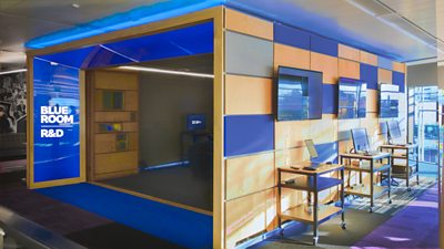 Blue Room lab in Salford with modular wheeled desks, TV screens, and touchscreen PCs set up to enable technology demonstrations
