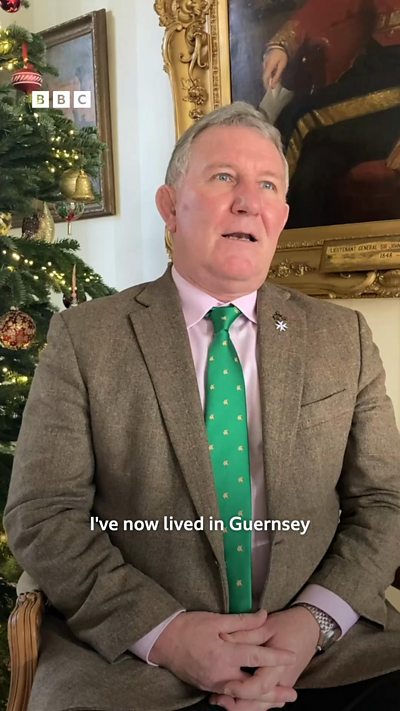 The lieutenant governor of Guernsey sits in front of a Christmas tree