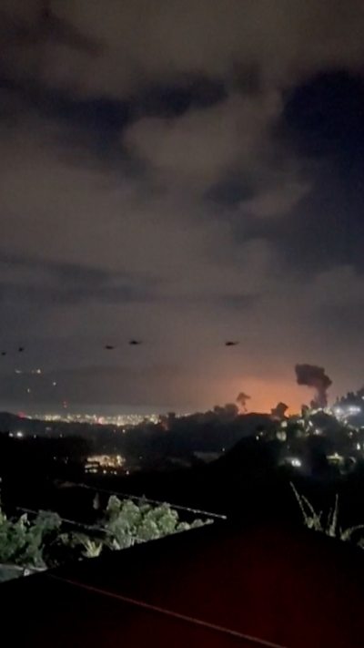 Trực thăng bay lượn trên thủ đô Venezuela trong khi các vụ nổ được nhìn thấy bên dưới.