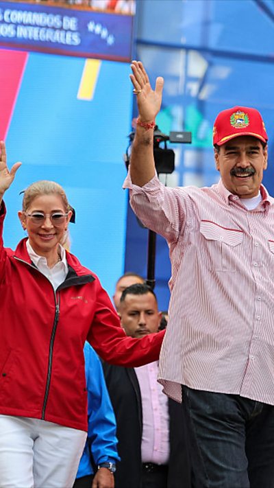 Cilia Flores and husband Maduro waving.