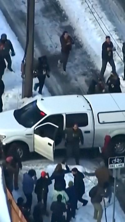 Image shows people surrounding a vehicle after fatal shooting.
