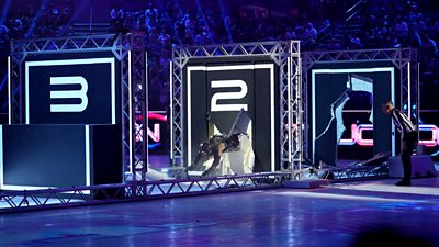 A blue-lit studio (Gladiators) shows someone jumping through a wall 
