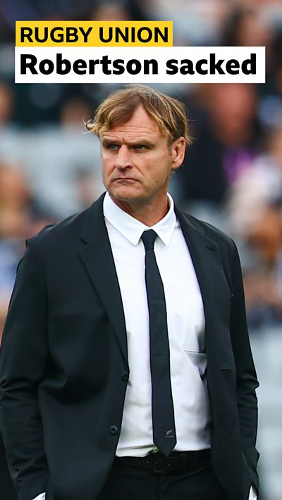 Former New Zealand head coach Scott Robertson. He is wearing a black jacket and tie.